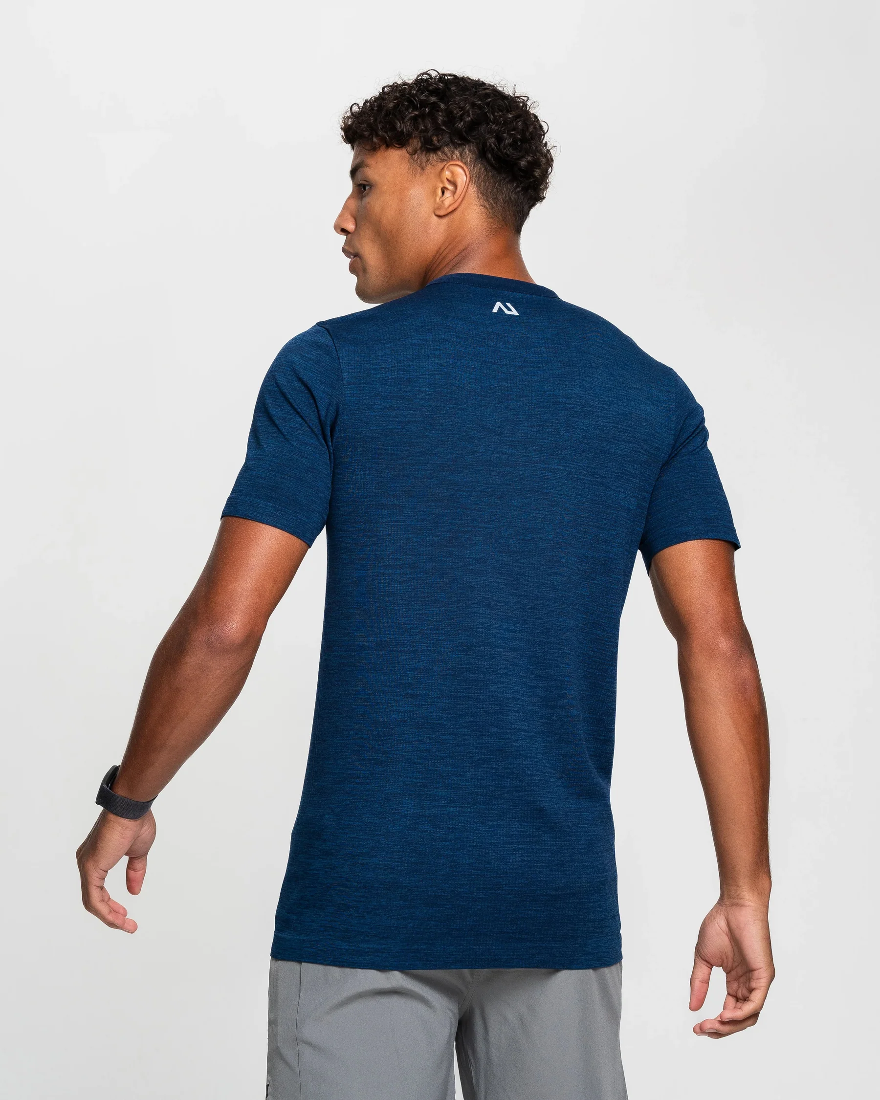 Stylized blue duotone portrait of a person facing the camera with arms crossed
